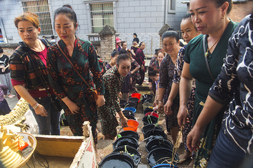 2、组照《泼水节中的浴佛》之二：参加浴佛，送来清水的妇女，在寺院门前台阶上用水桶排队，等候浴佛。