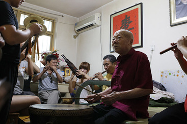 赵庚辰老人在家中和众弟子一起排练鼓乐，学鼓乐需要口传心授。