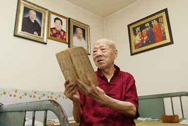 赵庚辰老人研读百年历史的鼓乐乐谱。