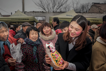 精挑细选 2018年3月18日，庙会上选购娃娃的少女。