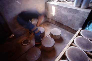 6、云南普洱茶“七子饼”的传统制作-将茶饼用石磨进行压制