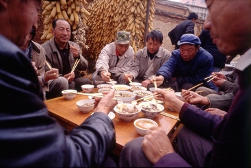 4、年猪饭-津津有味吃着年猪饭的村民