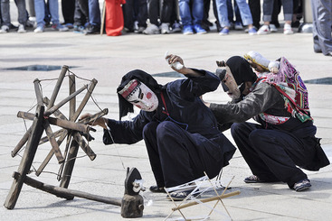 2013年6月8日是全国第八个文化遗产日，壮族铜鼓习俗在广西民族博物馆进行展演。这是天峨县的壮族农民在表演蚂拐民俗送背带。