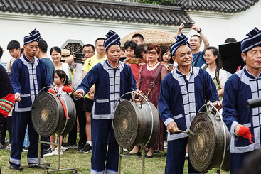 2024年4月13日，游人在广西“三月三”青秀山主会场的非遗村寨观看壮族铜鼓舞表演。