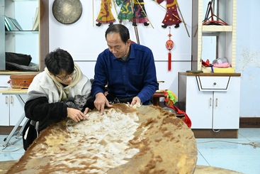 3.  方寸白布一盏舞台，尺把小人演绎华彩。面对一张张牛皮，州级非遗传承人贾继武和徒弟龚宇轩依然每天游走在他的皮影人生里。-1-277263-159****6326-3.  方寸白布一盏舞台，尺把小人演绎华彩。面对一张张牛皮，州级非遗传承人贾继武和徒弟龚宇轩依然每天游走在他的皮影人生里。.JPG
