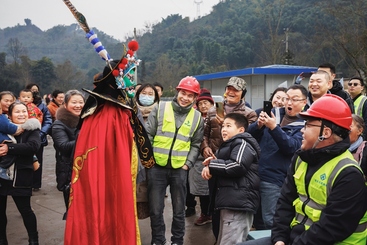 Z17443-7-277263-153****4267-文化惠民过大年（组照-5）表演变脸的川剧演员走下舞台与工地员工和附近村民互动。当地年年组织送文化下基层的活动很受群众喜爱。2024年1月摄于四川雅安市雨城区某工地。