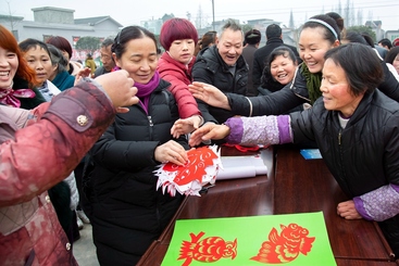 Z17443-9-277263-153****4267-中国剪纸在乡村（组照-1） 非遗传承人上官东平参加文艺家走基层活动，送剪纸到农村，受到村民们欢迎。剪纸在我国，特别是农村具有最广泛的群众基础。2016年1月摄于四川雅安市名山区解放乡。
