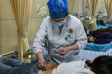 医生为患者腰部扎银针