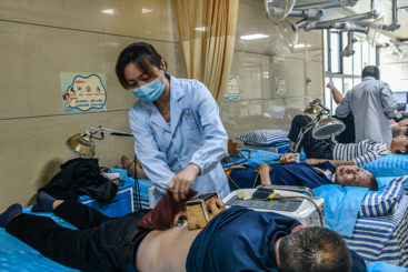 医生用艾绒为患者进行穴位上熏慰治疗