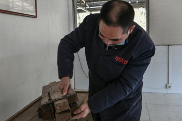 员工在用模具压中药材