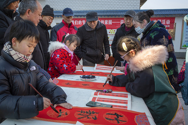 Z38227-2-277263-139****0426-4   2024.1.23  荆州市弥陀寺社区  小小“书法家”挥毫写春联。有很多居民和乡亲高兴地拿到了他们赠送的联，书法界后继有人。.jpg