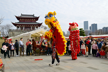 《舞狮迎新春》6-6、2025年1月30日，浙江金华，游人在金华市婺州古城景区万佛塔广场观看舞狮表演。