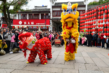 《舞狮迎新春》6-4、2025年1月30日，浙江金华，游人在金华市婺州古城景区保宁门广场观看舞狮表演。