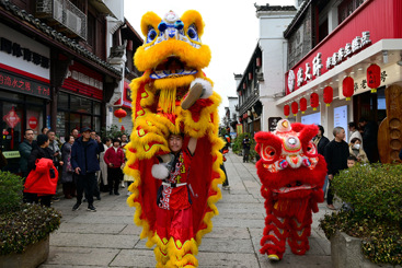 《舞狮迎新春》6-2、2025年1月30日，浙江金华，游人在金华市婺州古城景区古街上观看舞狮表演。