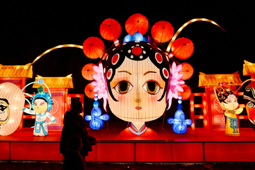 《璀璨花灯迎新春》6-2、游人在《婺剧脸谱》造型灯组前赏灯、打卡。